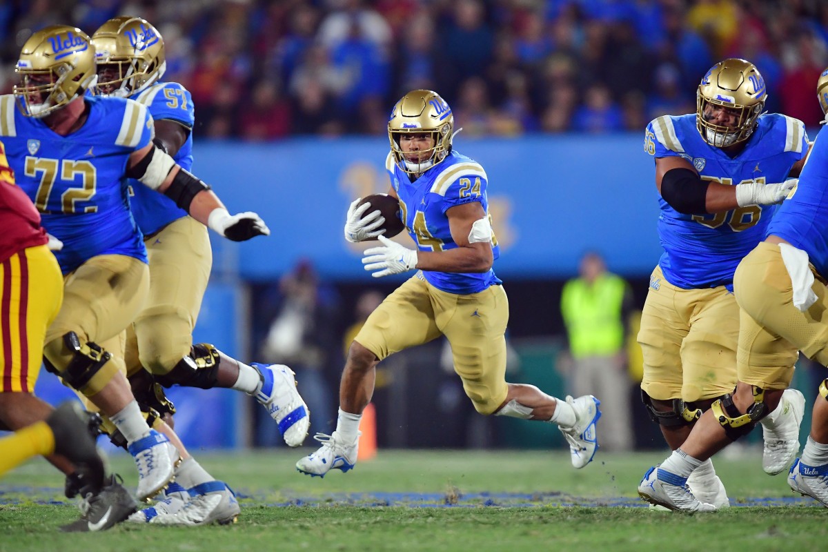 Nov 19, 2022; Pasadena, California, USA; UCLA Bruins running back Zach Charbonnet (24) runs the ball against the Southern California Trojans during the first half at the Rose Bowl. Mandatory Credit: Gary A. Vasquez-USA TODAY Sports
